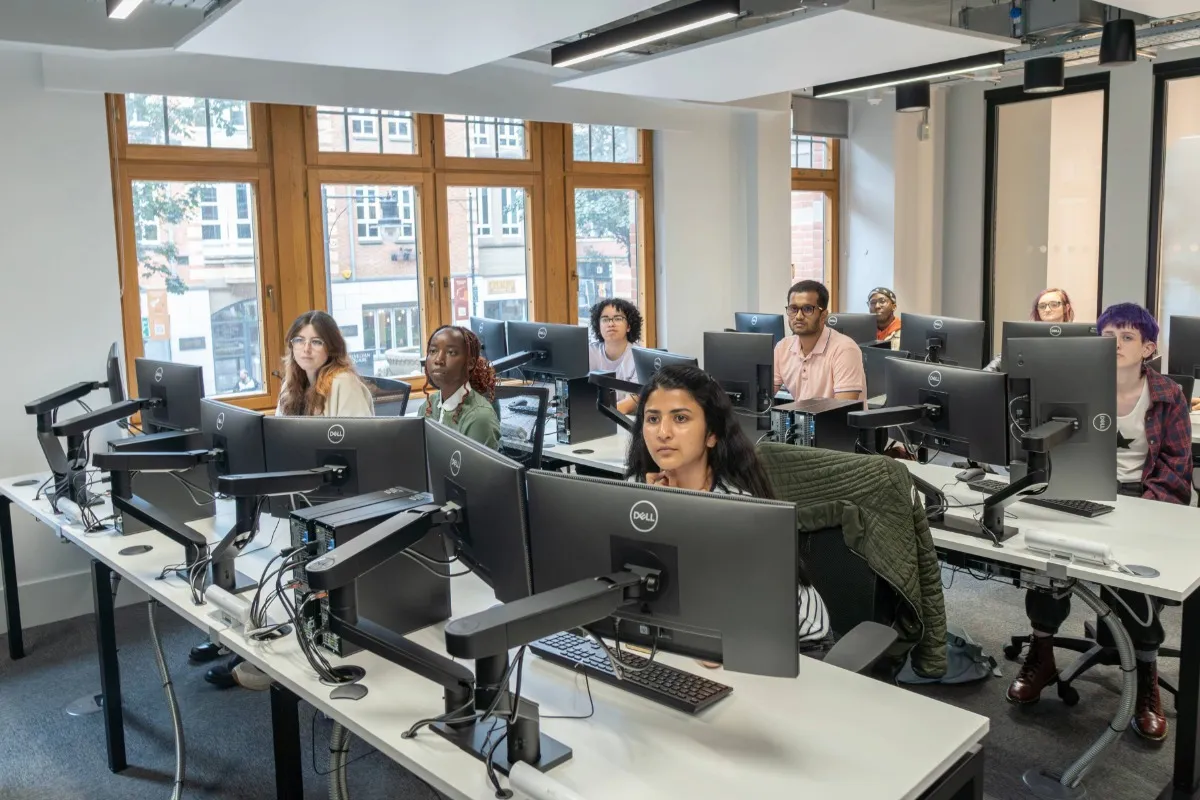 A group of students working in the trading room at Leeds City Campus..