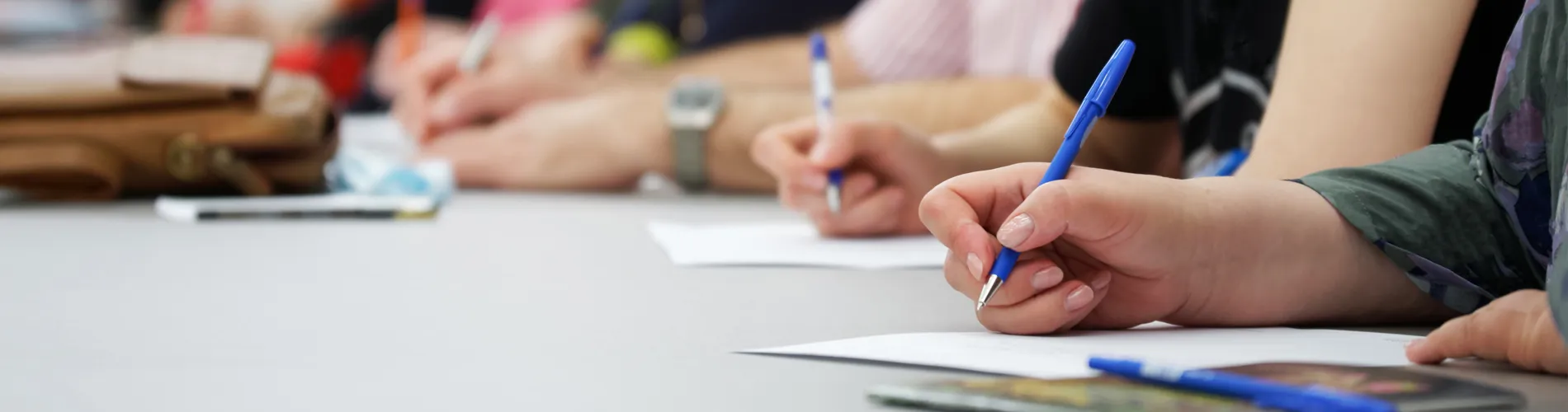Image of student hands writing in a notepad