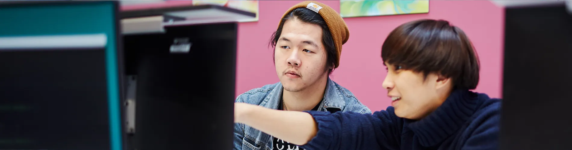 Two students working at a computer terminal.