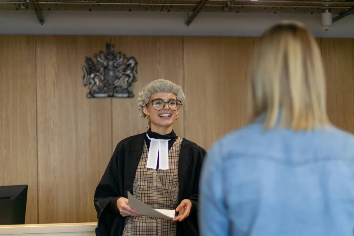 Law student practising in the moot court room at Leeds City Campus.