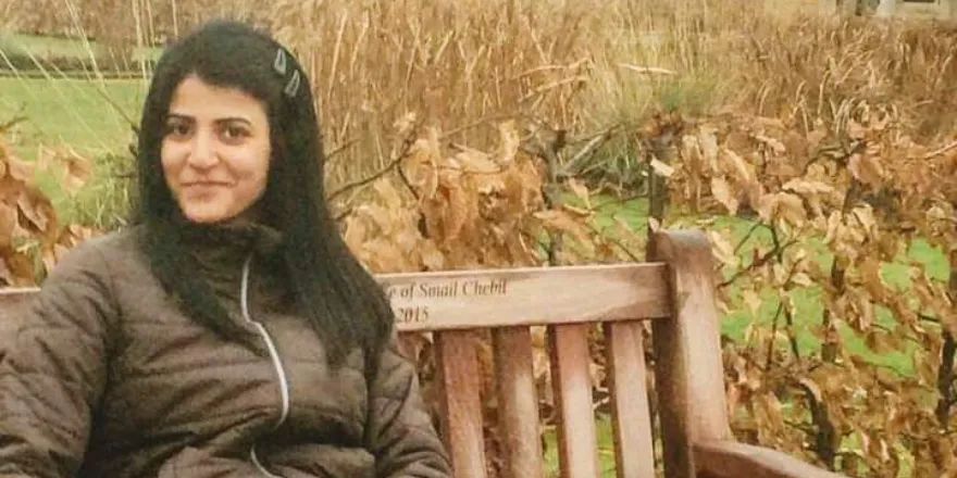 Female student sat on a bench.