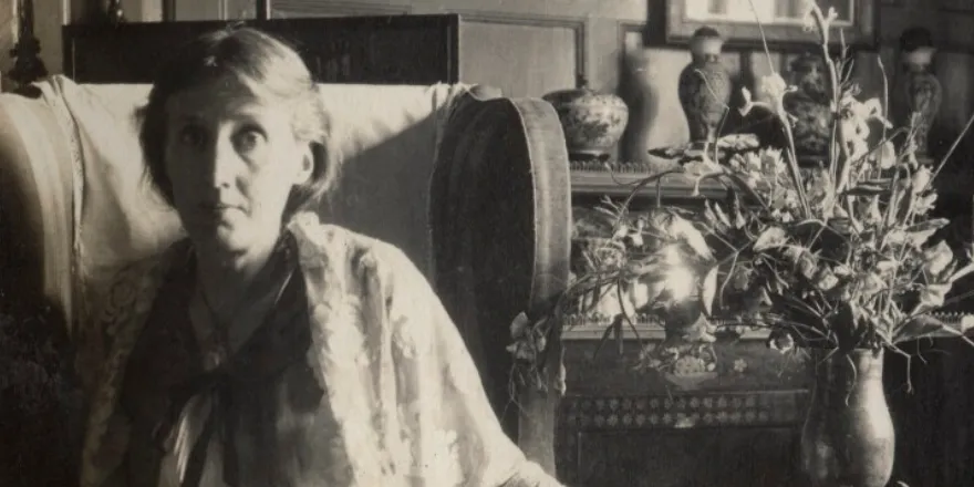 Black and white image of Virginia Woolf sat on sofa.