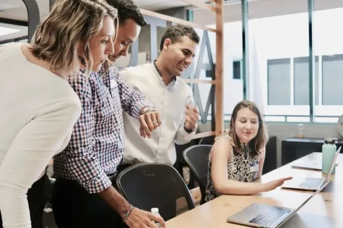 Teachers having a discussion with laptop .