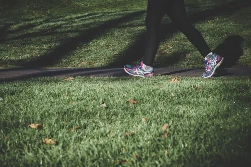 Female walking on grass in trainers .