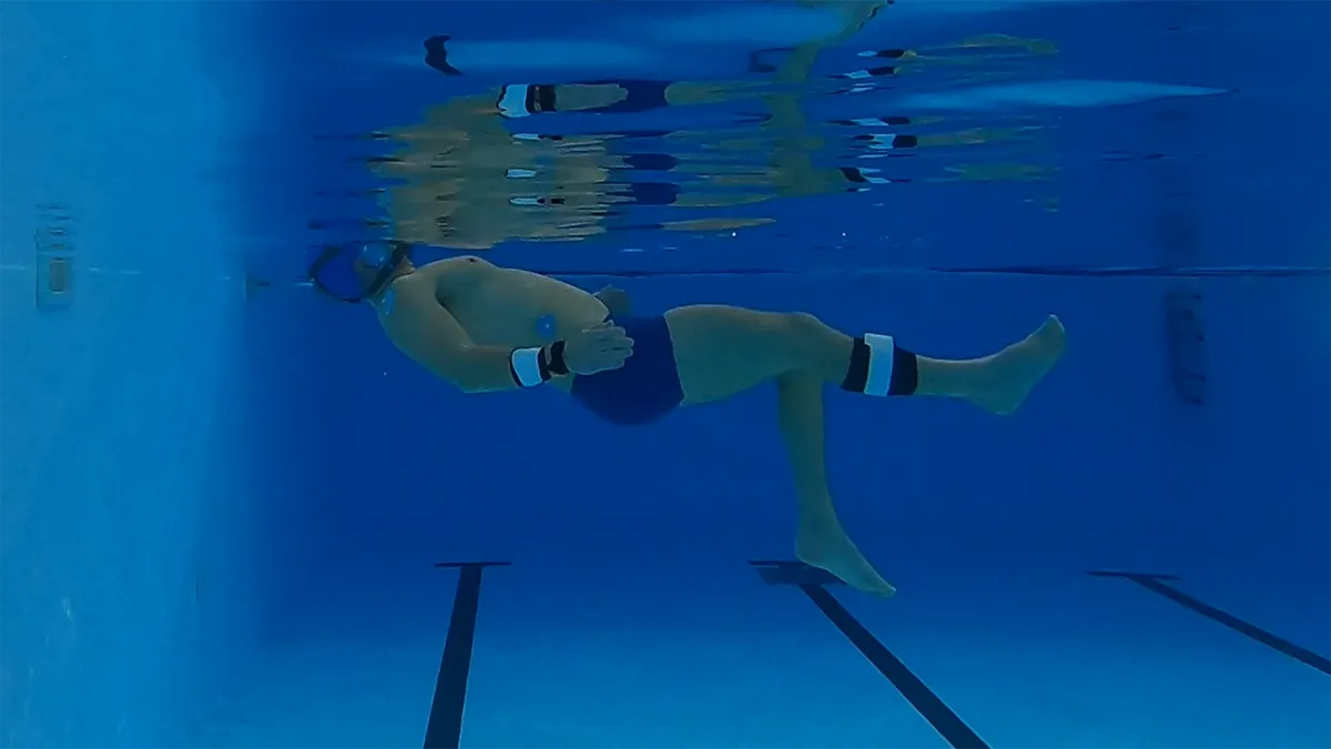 A man in a swimming pool as part of a research project looking at the human body in water and how they float..