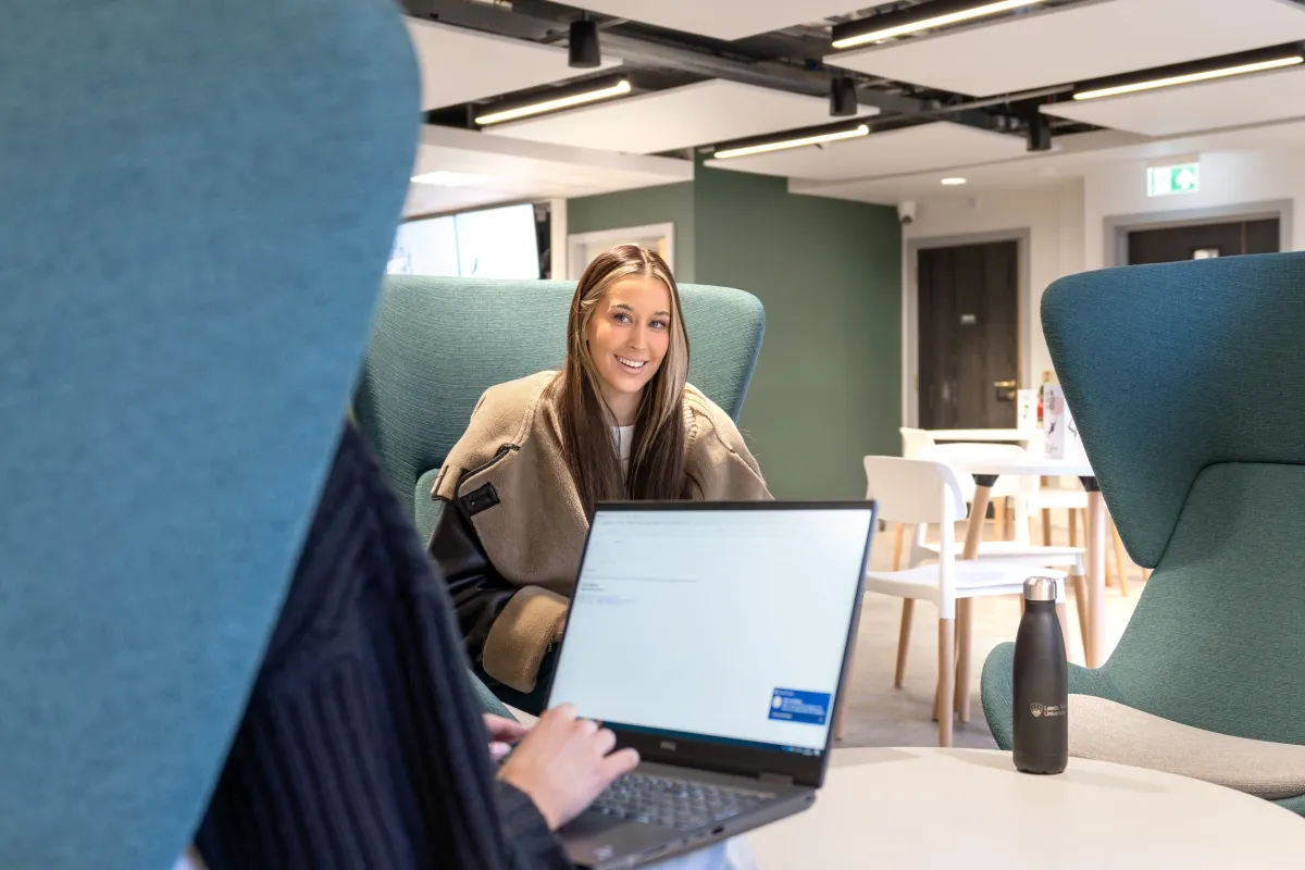 Students sat in chairs at the Leeds City Campus Cafe..