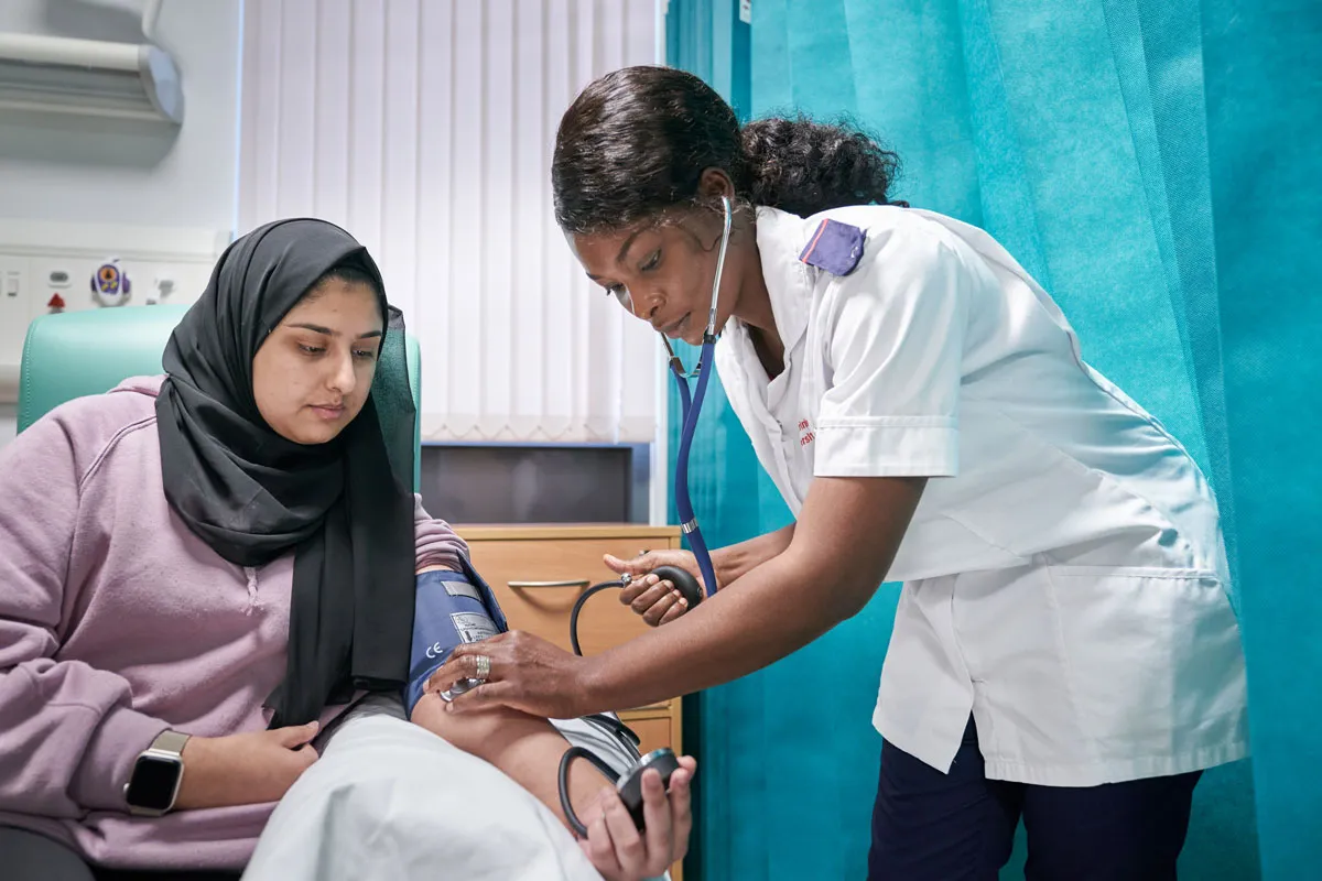 A nursing student at Leeds Trinity University takes a patient’s blood pressure during a practical training session..