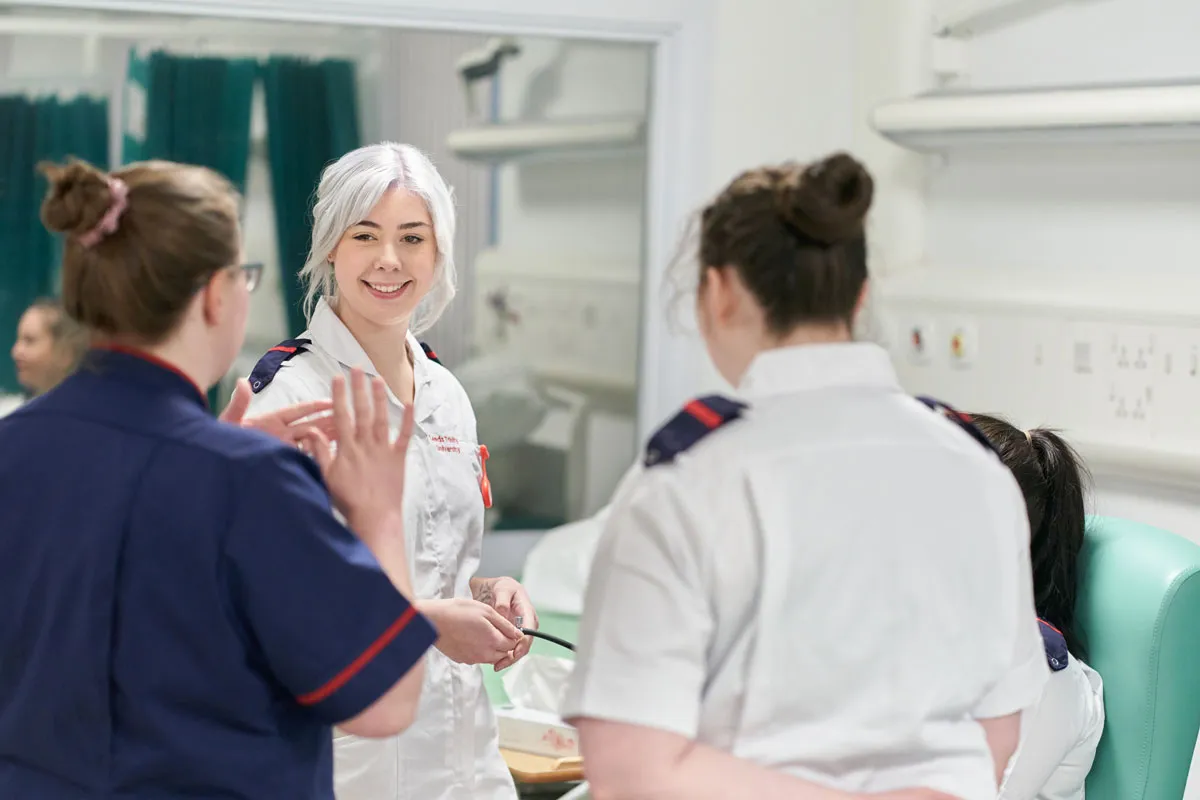 A group of nursing students talk with a lecturer during a clinical skills session at Leeds Trinity University..