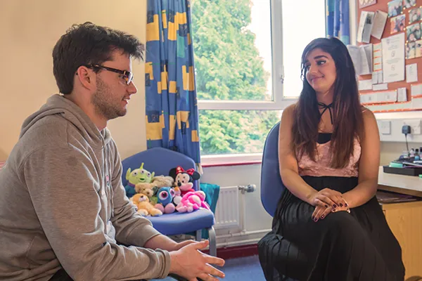 Two student talking in the bedroom of halls.