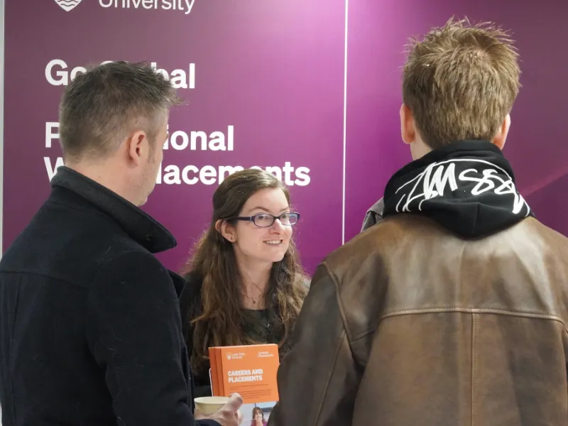 Staff member talking to guests at a Leeds Trinity Open Day