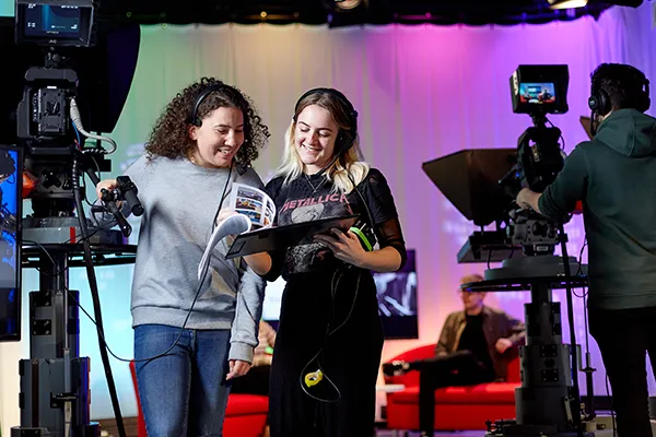 Student practicing media skills in TV studio.