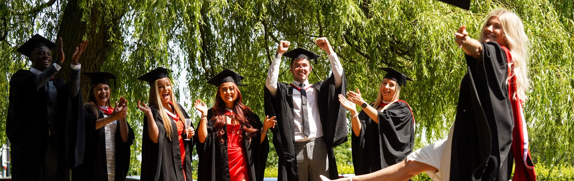 Group of students celebrating Graduation outside.