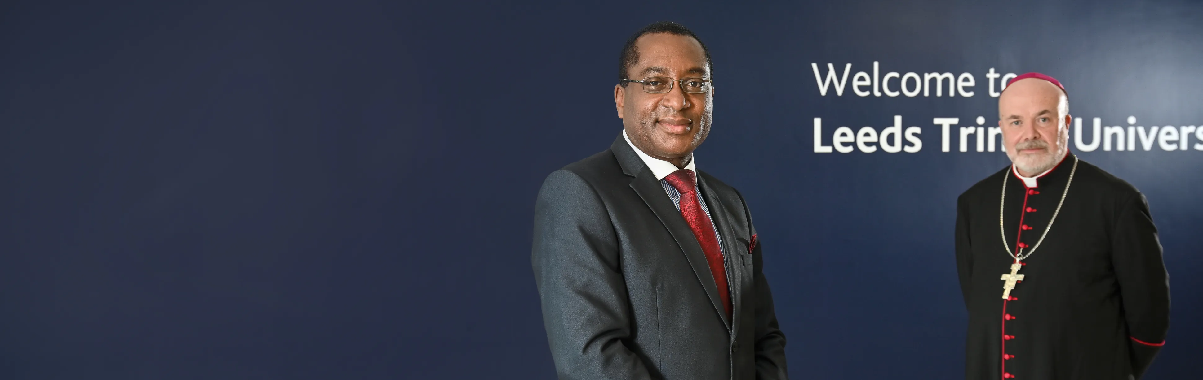 Professor Charles Egbu stood in the Leeds Trinity Atrium with The Right Reverend Marcus Stock, Bishop of Leeds