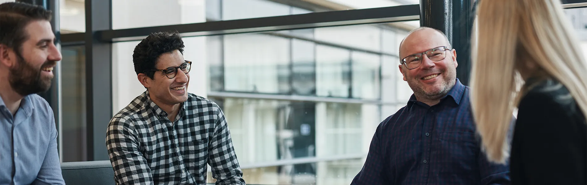 Staff sitting on benches chatting in corridor.