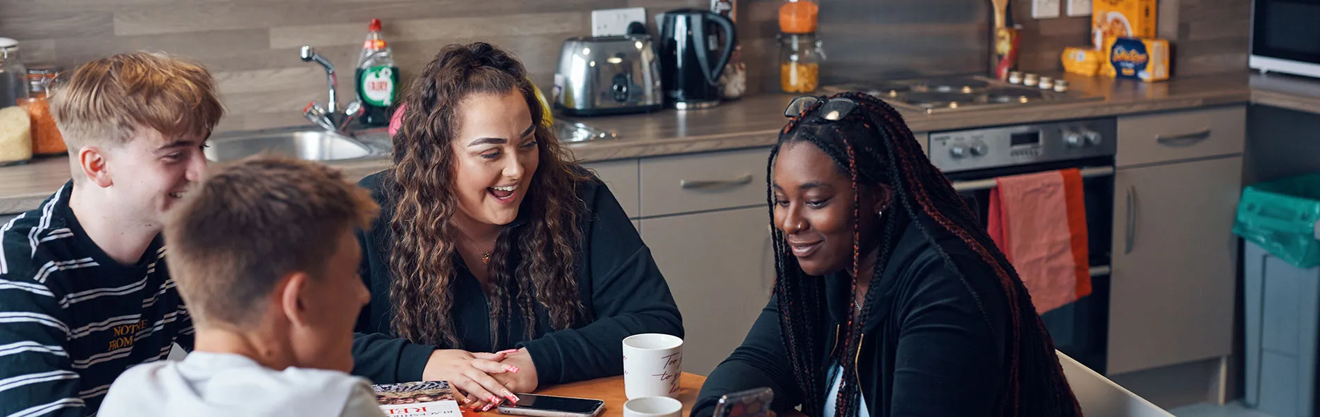 Four students sat round a kitchen table.