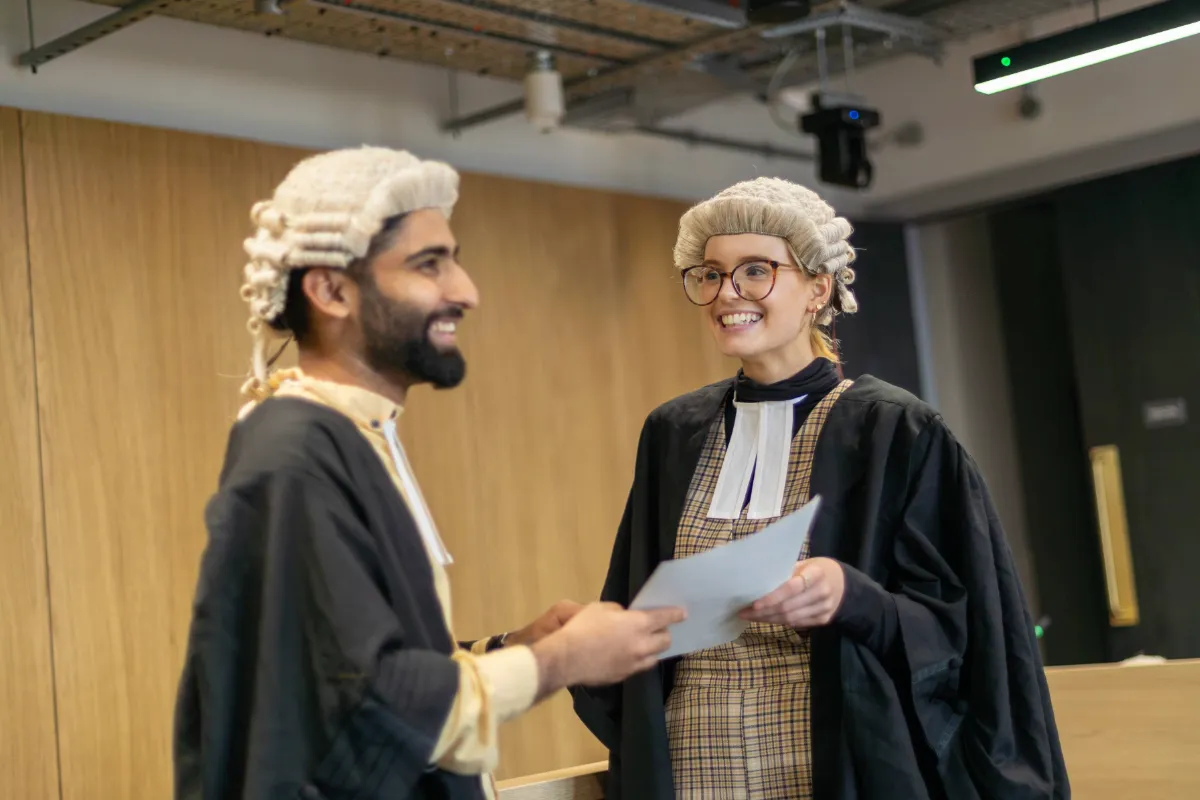 Two Law students standing in the mock courtroom at our Leeds City Campus