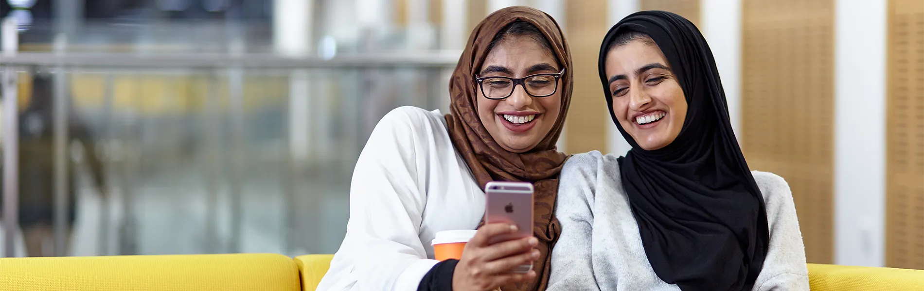 Two students smiling using a mobile phone