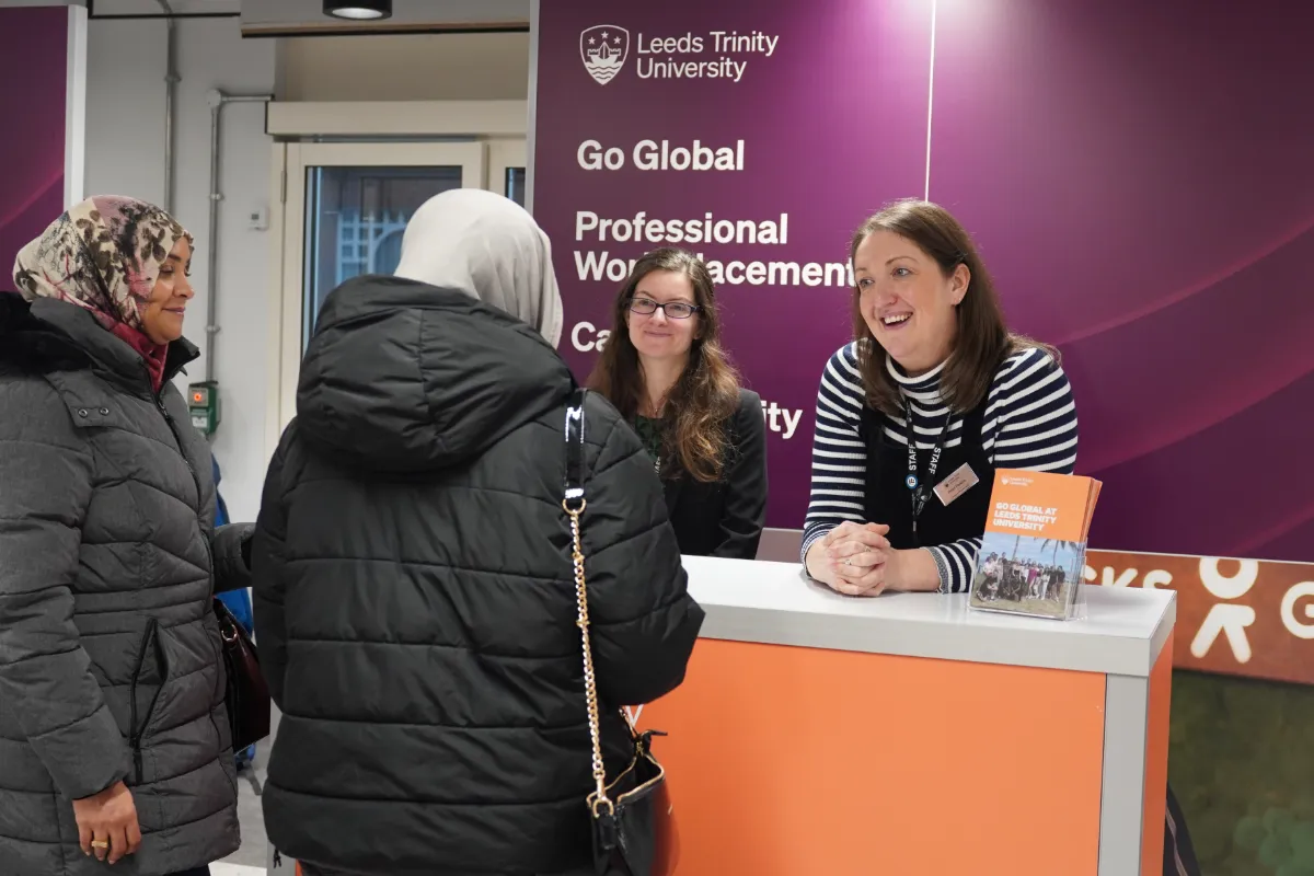 2 guests at our Leeds City Campus day chatting to staff members at the Information Fair