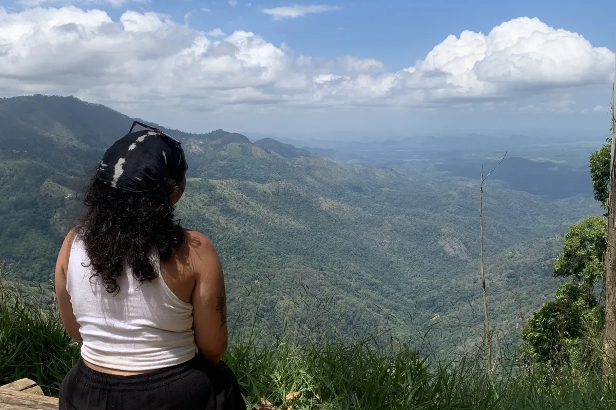 Student stat at the edge of a hill looking at mountains and valleys in Sri Lanka..