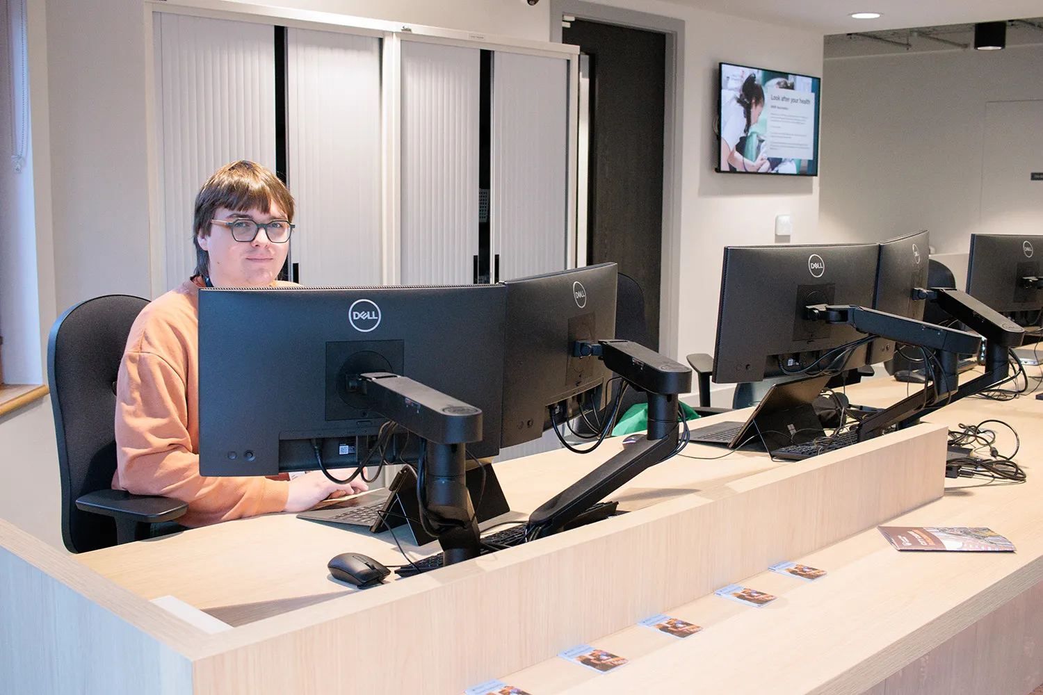 IT Services staff member sat at helpdesk.