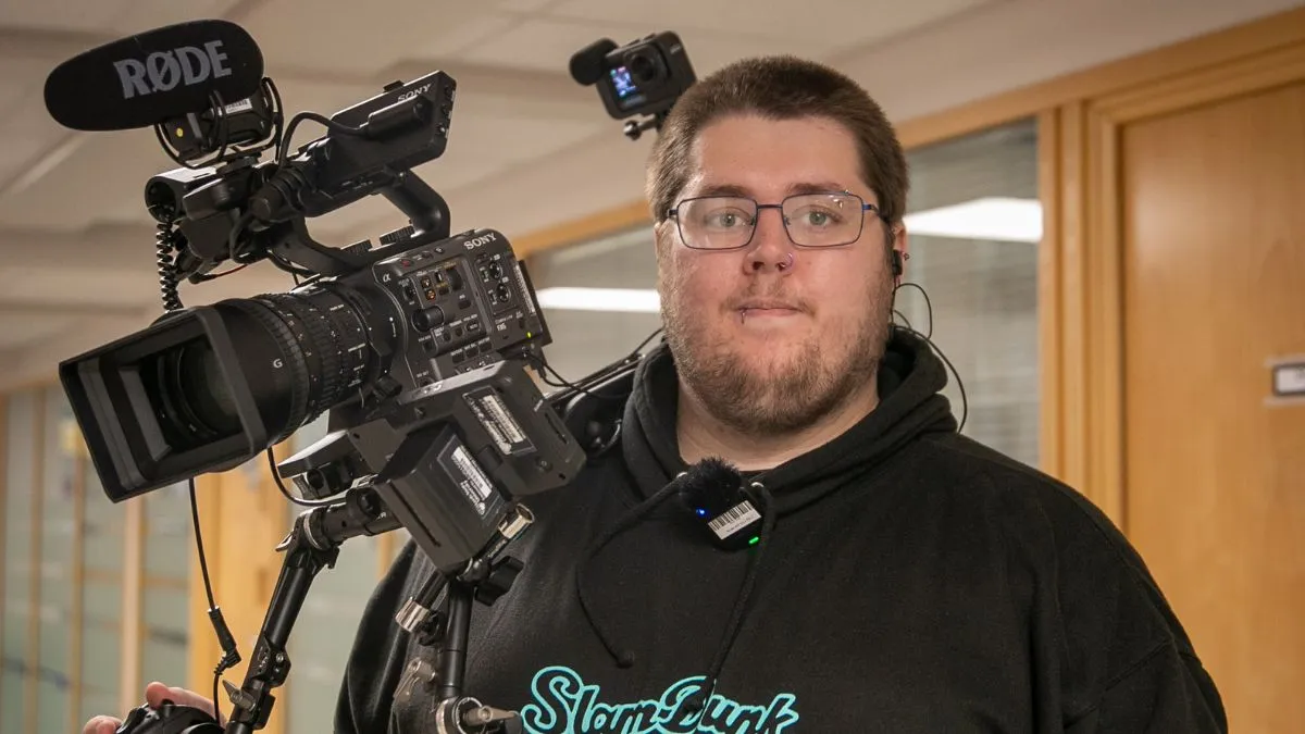A picture of Film student Ben Bridges holding a camera.
