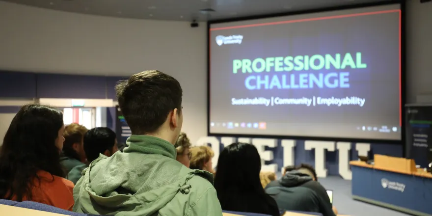 Back of students sat in lecture theatre with screen reading Professional Challenge.