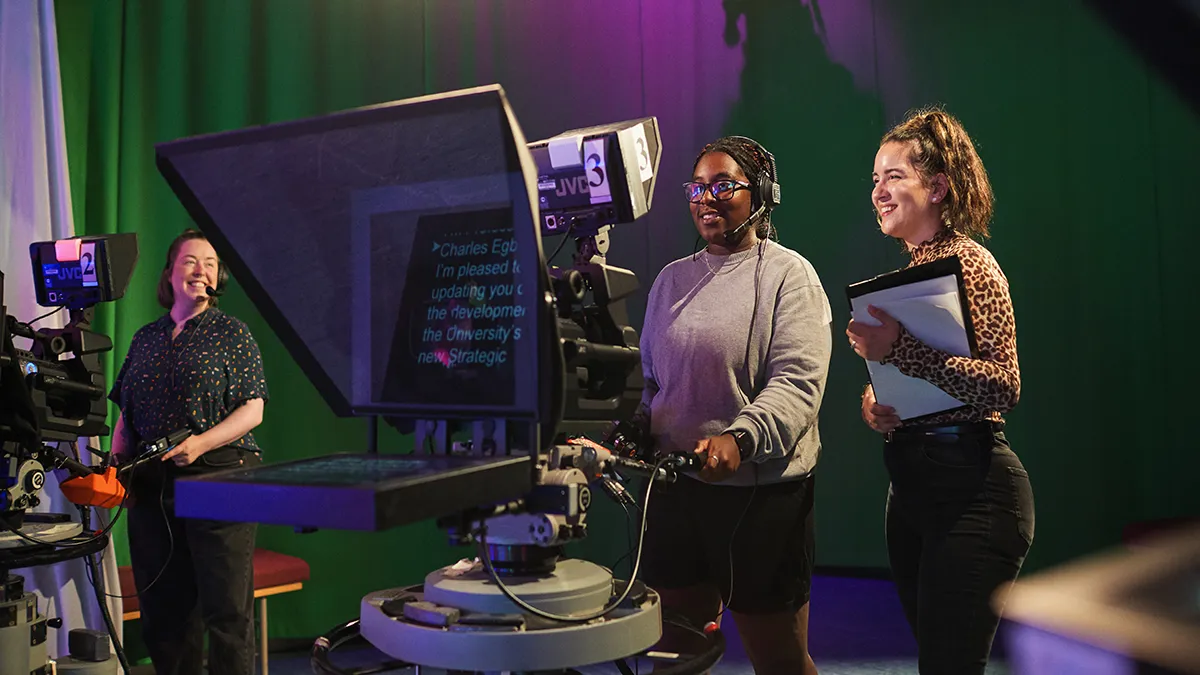 Students working on a prompter in the TV studio..