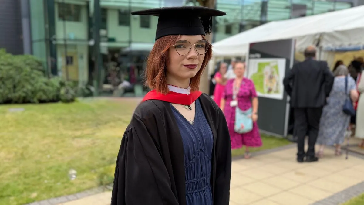 A picture of a Leeds Trinity University graduate in their cap and gown.
