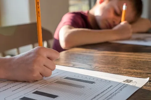 Child writing on white paper .