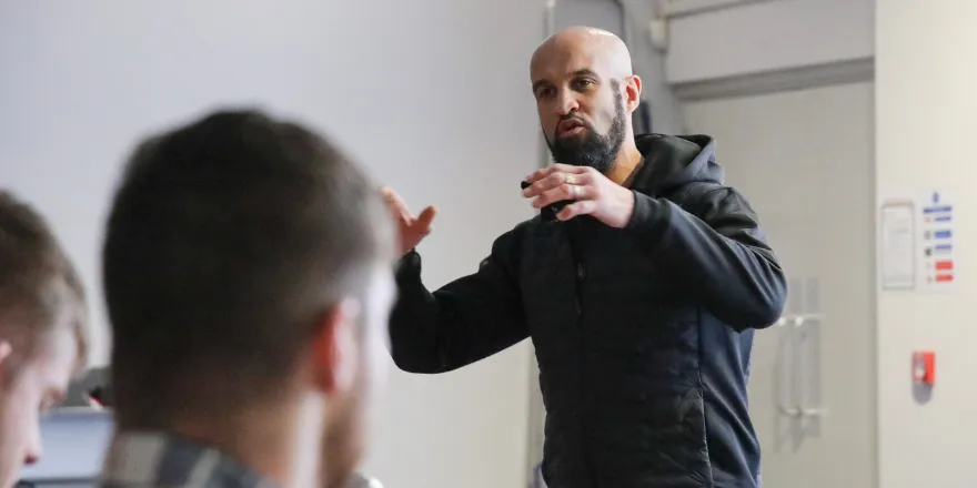 Male delivers talk to students.