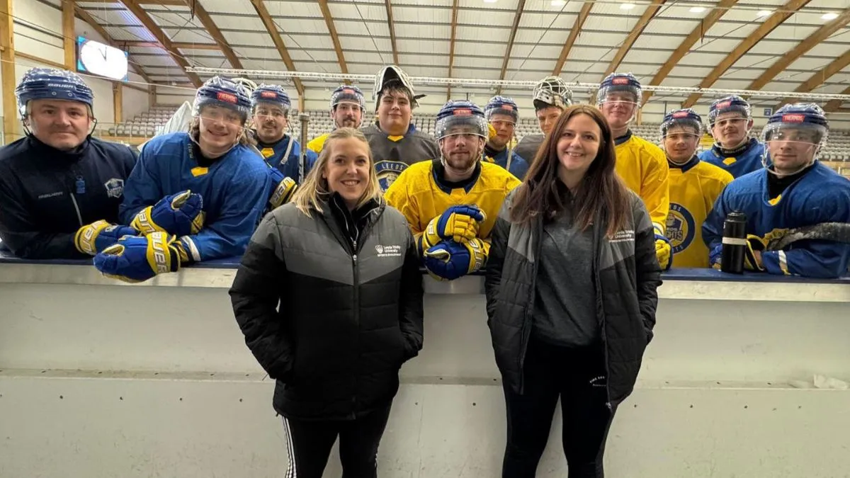 Two members of University staff pose for a picture with the Leeds Knights ice hockey team.