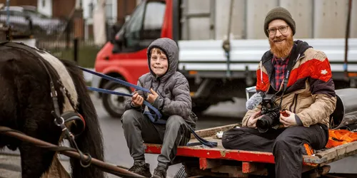 Film maker sat with boy on rag n bone cart