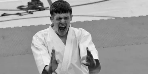 Black and white image of male athlete playing karate