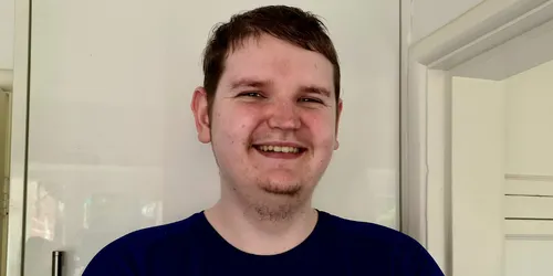 Male with short dark hair smiles for camera