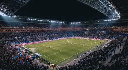 Image of a lit up football stadium from a distance