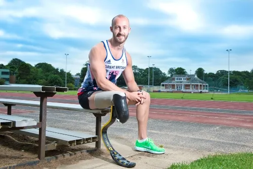 Gareth Dunn sat on side of running track