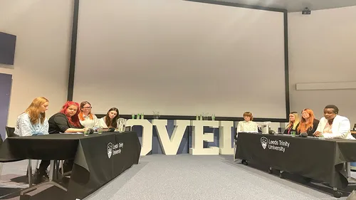Students sitting across from each other at a Primary Education debate at Leeds Trinity University.