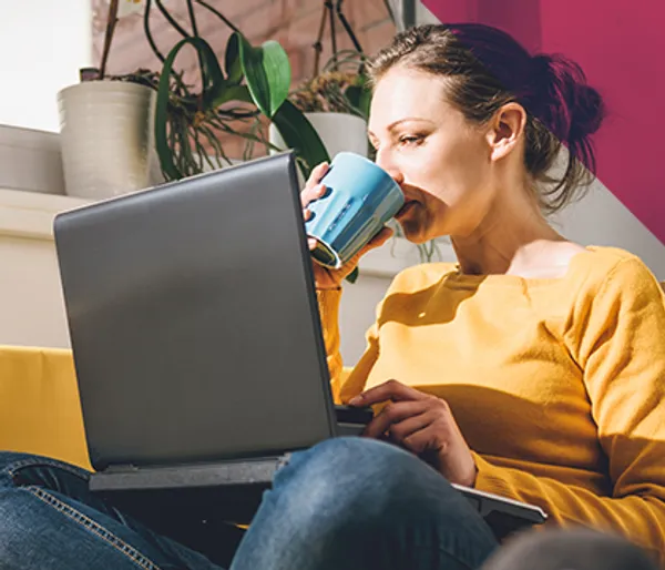 Student drinking coffee working on her laptop