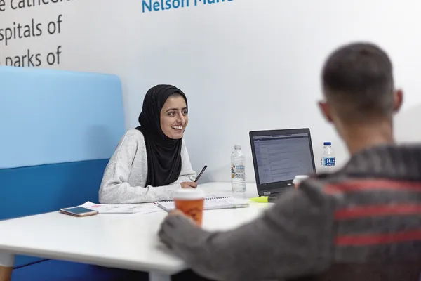 Students chatting around a table in the Andrew Kean Learning Centre.