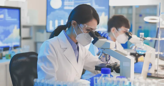 Female Biomedical Scientist using a microscope