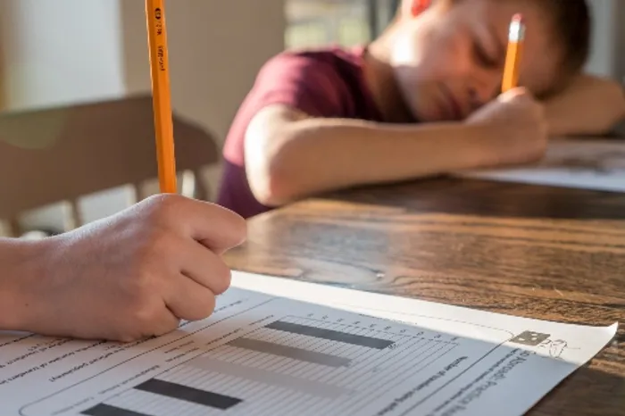 Child writing on white paper 