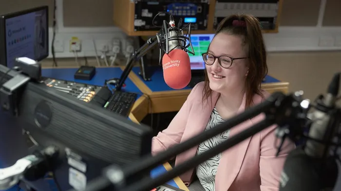 A student sits in a radio studio