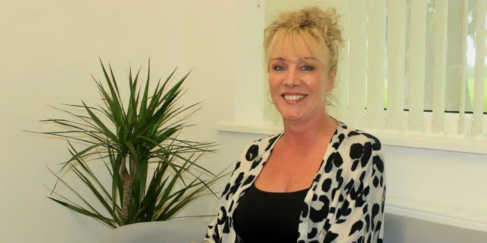 Blonde female sits on sofa