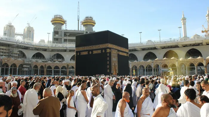 A crowd of people stood in front of the Kaaba, a stone building at the centre of Mecca