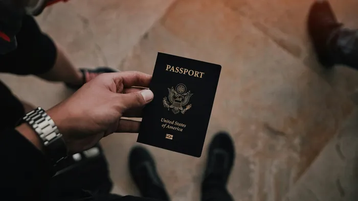 A hand holding a United States of America passport.