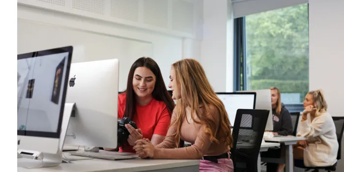 Students sat at computer looking at digital camera