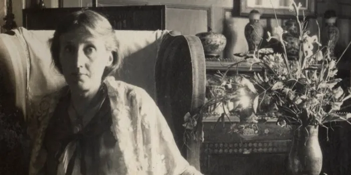 Black and white image of Virginia Woolf sat on sofa