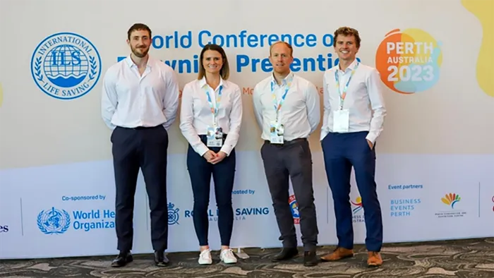 Four people in white shirts and black trousers posing at the Water Conference in Perth, Australia.
