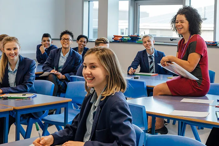 A teacher sitting with her students in a classroom