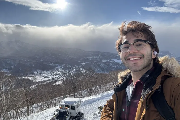 Uzayr Khan on exchange in Japan, stood in front of snowy mountain.
